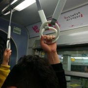 男子车厢内单手拉住两个吊环  同车乘客很尴尬