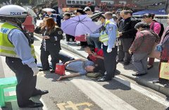 行人被撞受伤倒地  民警烈日下轮流执伞为他守护