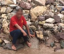 红衣男子坐江边欲轻生 双腿还拴着两块大石头
