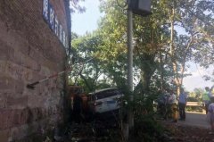小车擦挂电线杆后失控 撞上路旁院墙破损严重