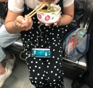 女子自带碗筷在车厢内吃东西 还一边看着手机