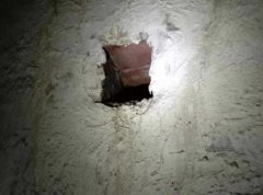 小区通道墙壁不断渗水形成积水 过往居民险滑倒