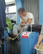 男子坐在车厢连接处 还将脚搭在绳子上