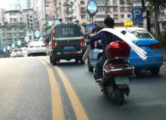 秀身手？男子肩扛一捆约6米长的塑胶管骑车上路