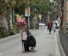 太危险！男子拿板凳坐路中间叫卖冰糖葫芦