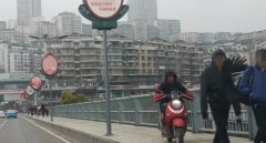 男子骑电动车驶上大桥人行道 穿梭于人群之间